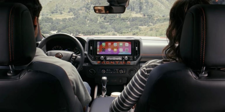2026 Nissan Frontier interior view looking forward between 2 occupants showing 12.3 screen