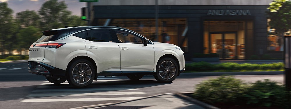 2026 Nissan Murano navigating a right turn in near business at dusk