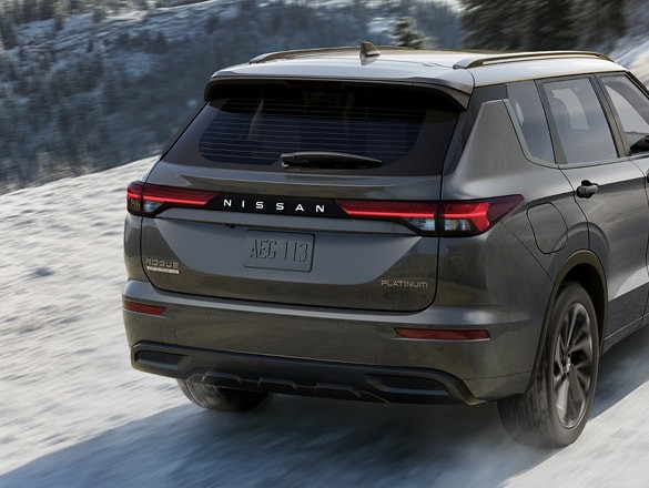2026 Nissan Rogue Plug-in Hybrid 3/4 rear view kicking up dirt on mountain road.