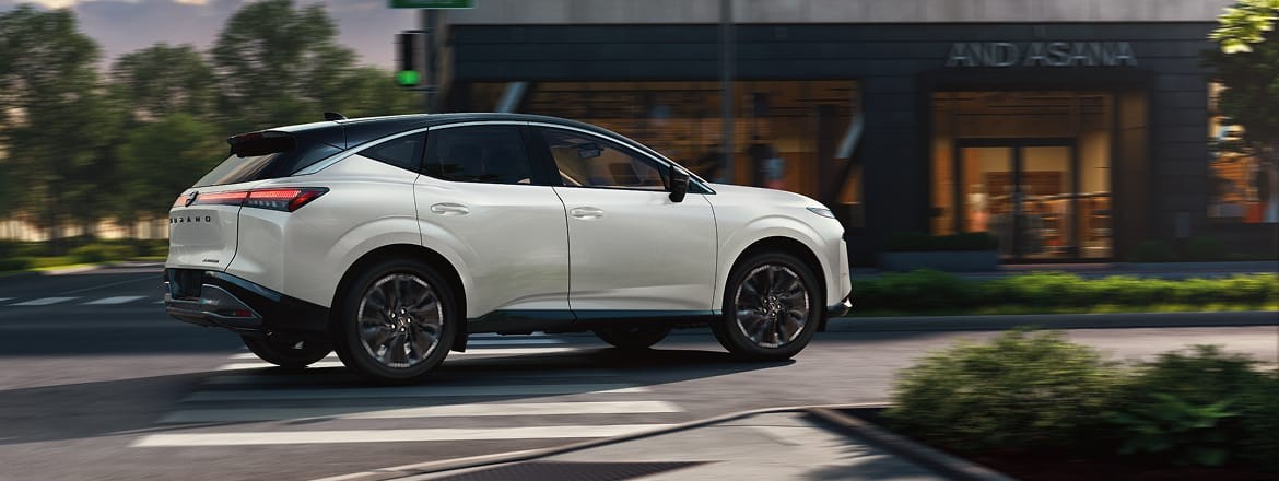 2027 Nissan Murano navigating a right turn in near business at dusk